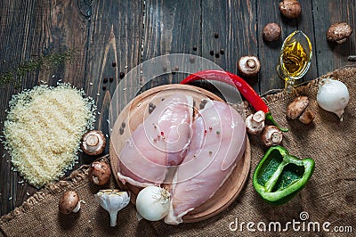 Chiken breast On a cutting board with herbs different fruits and vegetables on rustic wooden background top view Stock Photo