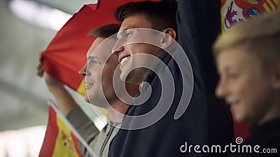 Child and adult Spanish football fans waving flag, singing national anthem Stock Photo