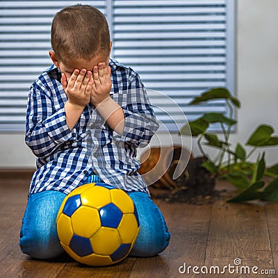 The child is afraid of punishment. He smashed the flower pot Stock Photo