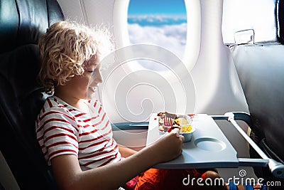 Child in airplane. Kids fly. Children flight meal Stock Photo