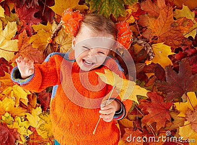 Child in autumn orange leaves. Stock Photo