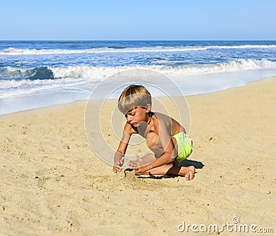 The child in a bathing suit playing on the sand Stock Photo