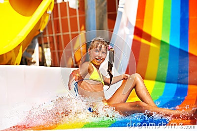 Child in bikini sliding water park. Stock Photo