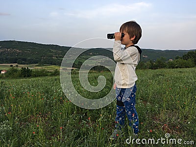 Child with binocular, on the hillside Stock Photo