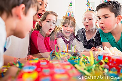 Child on birthday party blowing candles on cake Stock Photo