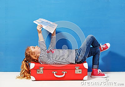 Child blonde girl with pink vintage suitcase and city map ready for summer vacation. Travel and adventure concept Stock Photo