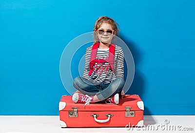 Child blonde girl with pink vintage suitcase ready for summer vacation. Travel and adventure concept Stock Photo