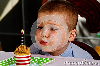 Child blowing out candle Stock Photo