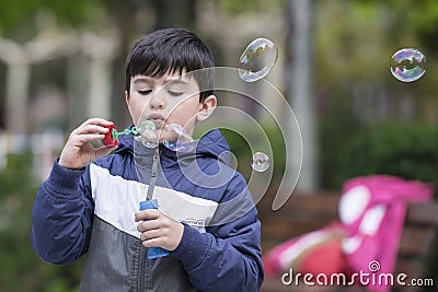 Child blowing soap bubbles outdoors Stock Photo