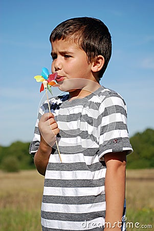 Child blowing windmill Stock Photo