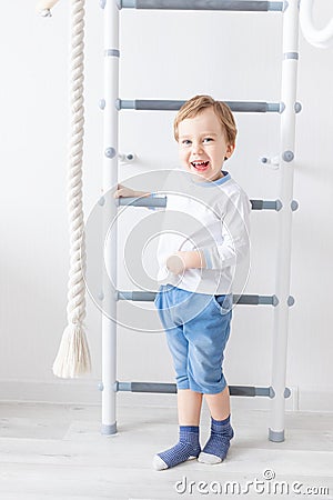 A child a boy climbs on the Swedish wall of the house Stock Photo