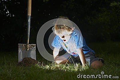 Child boy have unearthed a treasure in the grass Stock Photo