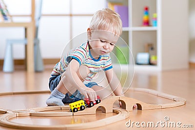 Child boy playing in his room with a toy train Stock Photo