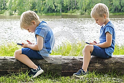 Child boy sits slouching hunched back bent,neck and straight,looks phone,over device.correct Stock Photo