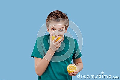 Child boy taste a fresh lemon, sour taste, make grimace, Stock Photo