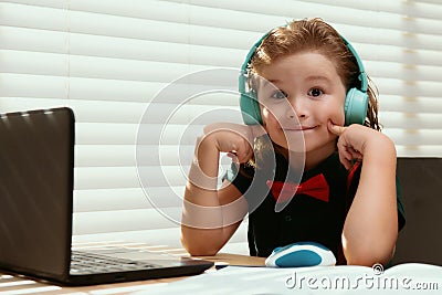 Child boy using a laptop and study online lesson. Pupil at school. Cute child using laptop computer, studying online. Stock Photo