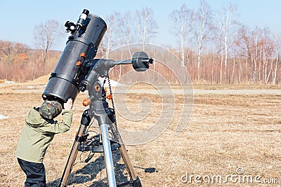 Child boy watching the sun through a telescope on a tripod at the observatory for observation of stars and planets Stock Photo