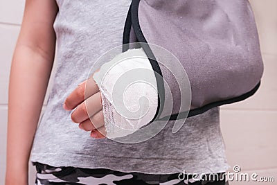 A child broken arm in plaster case and textile fixing bandage, hand injury because of accident, forearm bones fracture Stock Photo