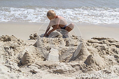 Child build a castle in the sand Stock Photo