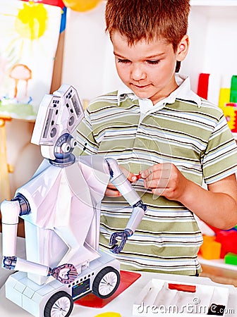 Child build robot toy. Kid engaged robotics in programming classes. Stock Photo