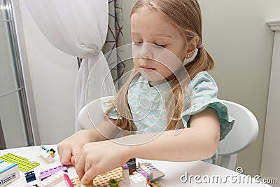 Child builds with constructor bricks, plays with toys Stock Photo