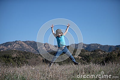 Child camping, happiness and freedom movement kids concept. Excited smiling kid boy jumping. Stock Photo