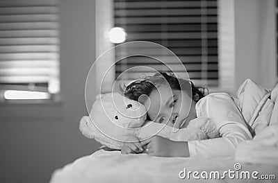 Child cannot sleep on bed at night in bedroom. Kid having sleeplessness. Kid boy sleeping in bed with night light. Stock Photo
