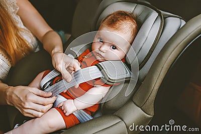Child in car mother putting baby in safety car seat Stock Photo