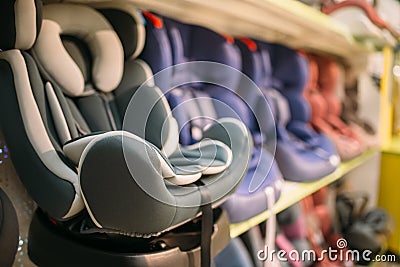 Child car seats variety on shelf in store, nobody Stock Photo