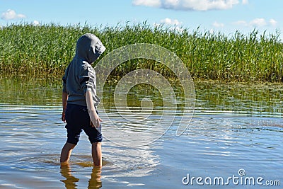 Child catches fish by hands. Cheerful childhood Stock Photo