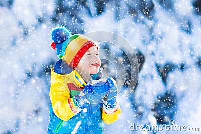 Child catching snow in winter park Stock Photo