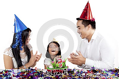 Child celebrates birthday party with her parents Stock Photo