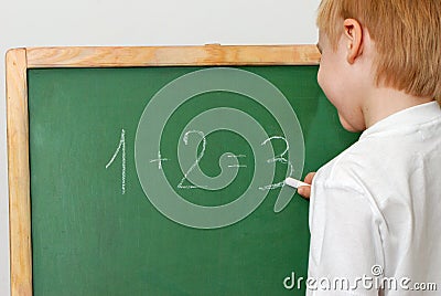 The child with a chalk near a board Stock Photo