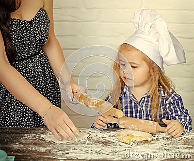 Child Childhood Children Happiness Concept. Child with serious face learning to roll dough Stock Photo