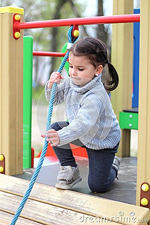 a child is climbing a tightrope in the playground Stock Photo