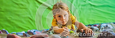 Child climbing on a wall in an outdoor climbing center BANNER, LONG FORMAT Stock Photo