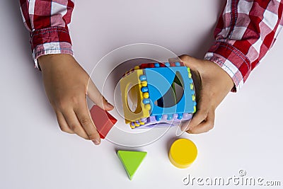 The child collects the cube sorter constructor. Puzzle cube sorter, an early development concept Stock Photo