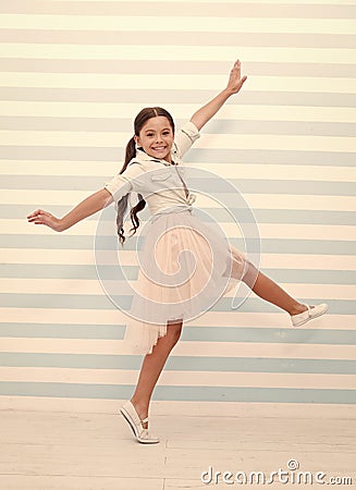 Child concept. Happy little child dancing. Child girl smile in fashion dress. Child and childhood. sense of freedom Stock Photo