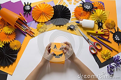 The child creates a hand-crafted pumpkin. Children`s hands. Stock Photo