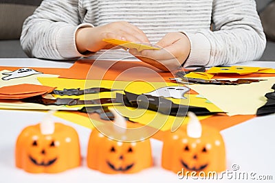 A child creates a pumpkin out of paper. Origami for Halloween, preparation Stock Photo