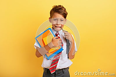 Child cries because he has a lot of school homework. Emotional expression. Yellow background Stock Photo