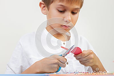 Child cutting red paper heart with scissors Stock Photo