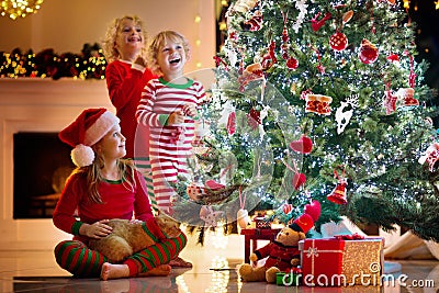 Child decorating Christmas tree. Kid on Xmas eve Stock Photo