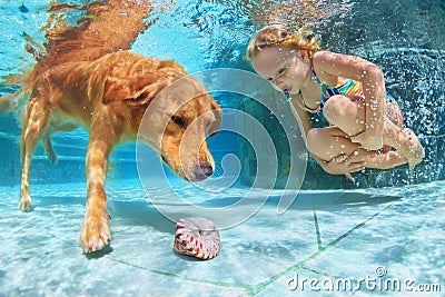 Child with dog dive underwater in swimming pool Stock Photo