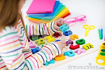 Child doing homework for school. Kids learn and paint. Stock Photo