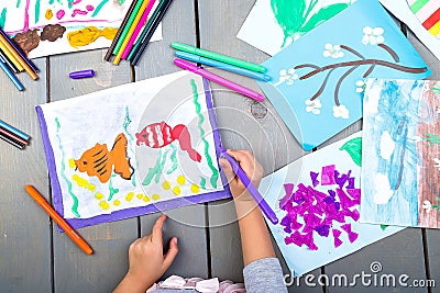 Child drawing. Top view of child hands with pencil painting picture on paper. Kid drawings. Stock Photo