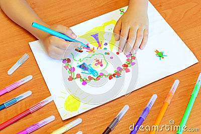 Child draws felt-tip pens. Small child holds a blue felt-tip pen in hand and draws abstract princesses castle Stock Photo