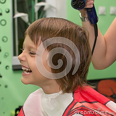 Child dries the hair in a hair salon Stock Photo