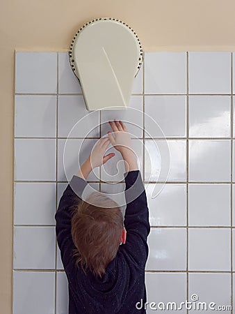 Child dries hands in an electric hand dryer Stock Photo