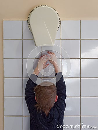 Child dries hands in an electric hand dryer Stock Photo